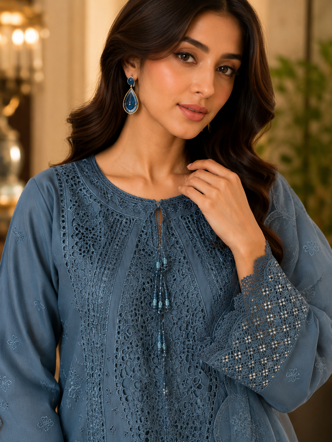 Woman wearing a blue embroidered top with intricate designs.